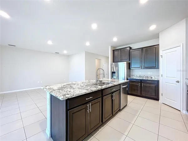 a kitchen with a sink a counter top space cabinets and stainless steel appliances