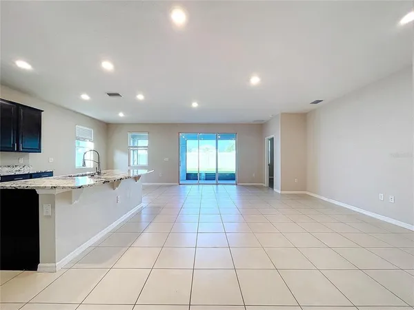a large kitchen with a stove a sink a microwave and cabinets
