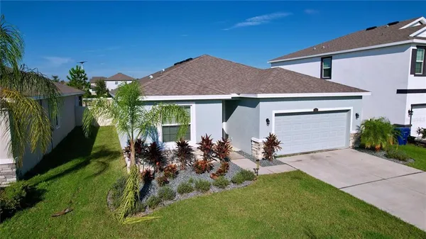 a view of a house with backyard sitting area and garden