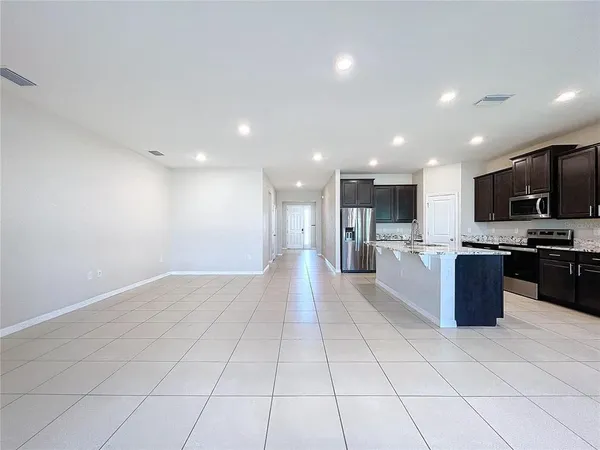 a large kitchen with a large counter top stainless steel appliances and cabinets