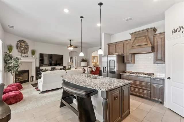 a open kitchen with a sink a stove and chairs