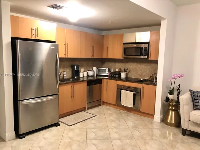 a kitchen with stainless steel appliances granite countertop a refrigerator sink and microwave