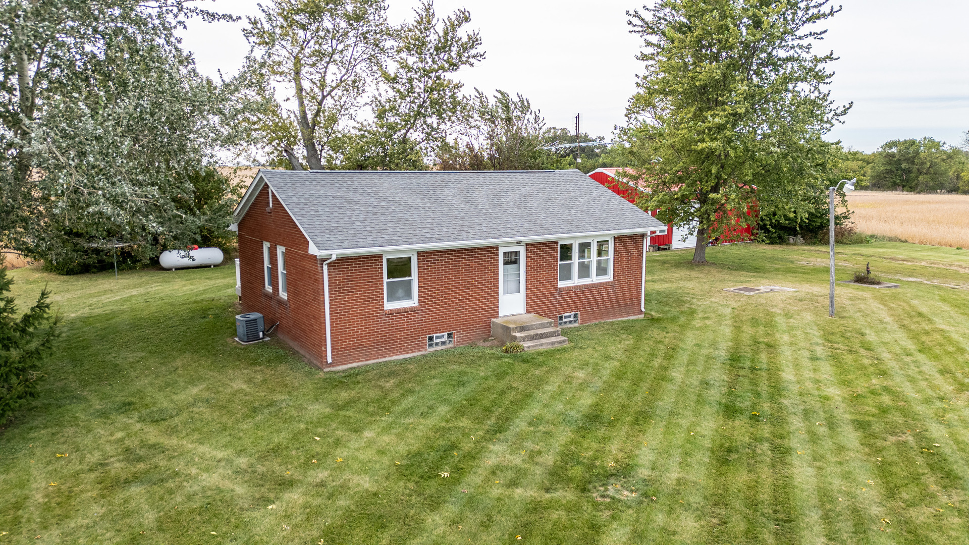 a aerial view of a house with yard and a tree