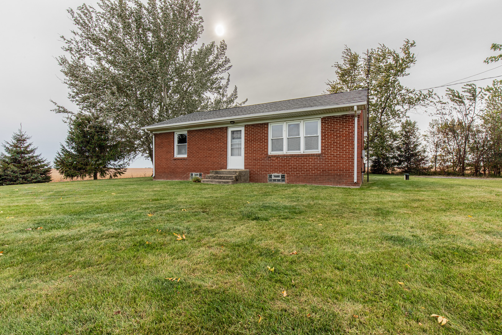 4705 East 7th Road Earlville, IL 60518 - Photo 18 of 21 a front view of house with yard and trees in the background