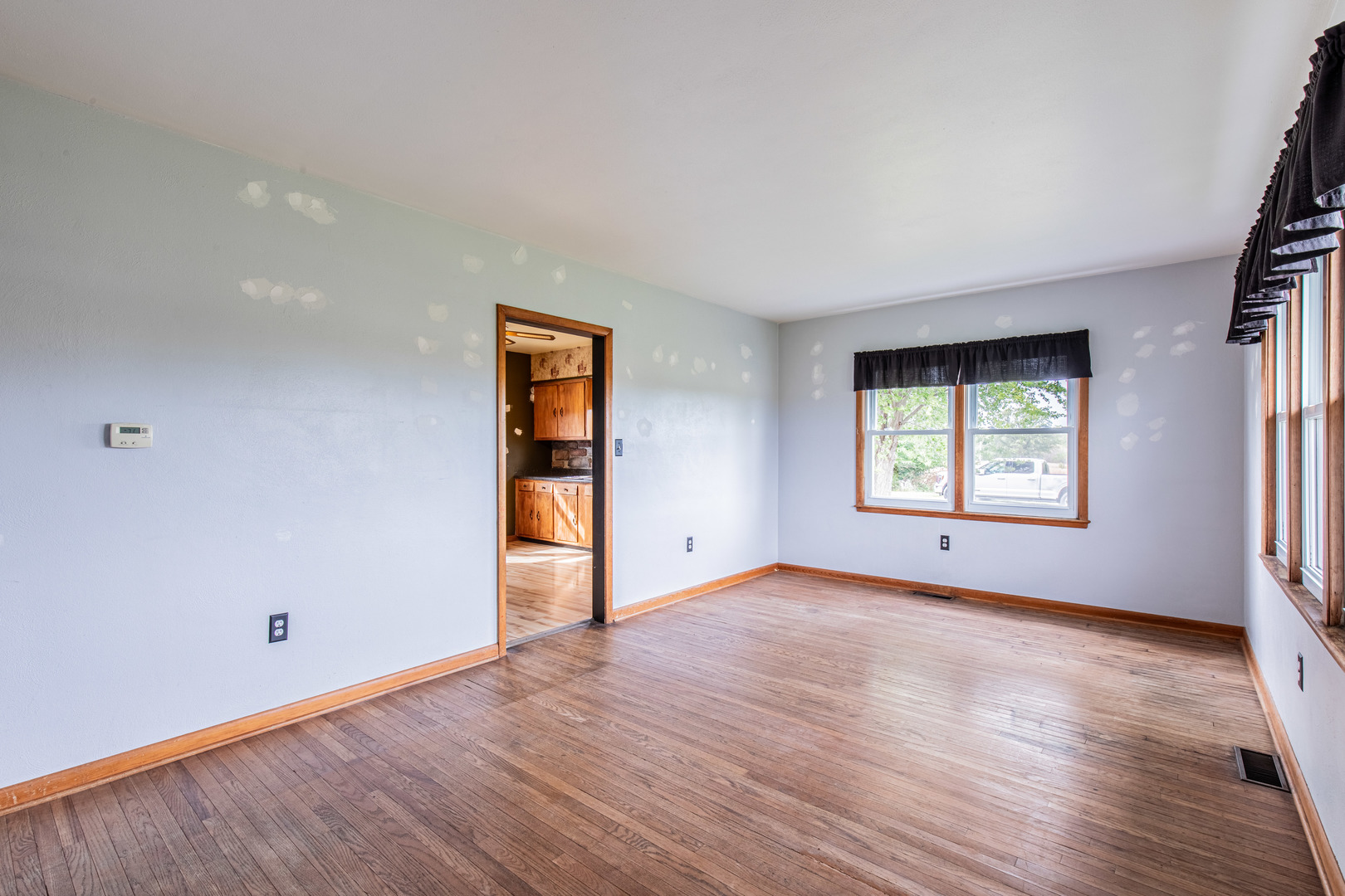 4705 East 7th Road Earlville, IL 60518 - Photo 2 of 21 an empty room with wooden floor and windows