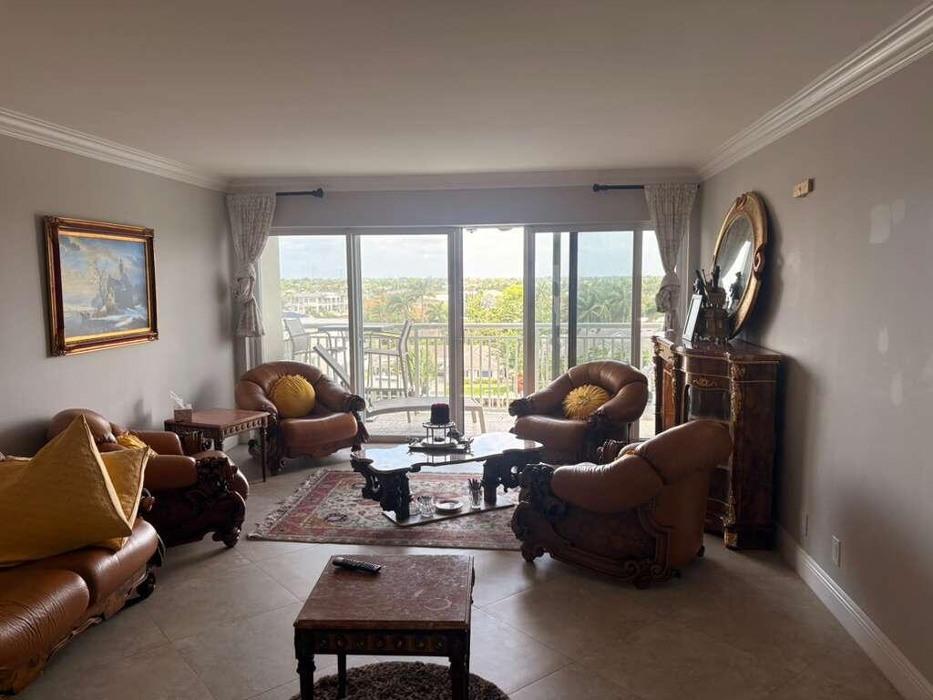 2611 North Riverside Drive, Unit 703 Pompano Beach, FL 33062 - Photo 60 of 81 a living room with furniture a lamp and a floor to ceiling window