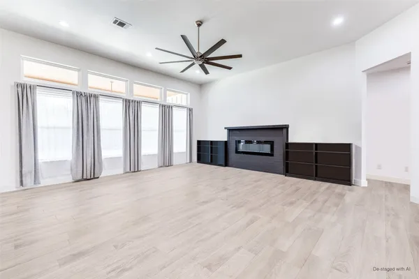a view of an empty room with cabinet and a window