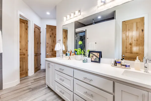 a bathroom with a double vanity sink mirror and shower