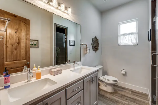 a bathroom with a sink a toilet and mirror