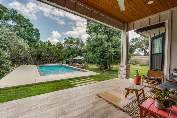 a view of a patio with table and chairs potted plants with wooden floor and fence