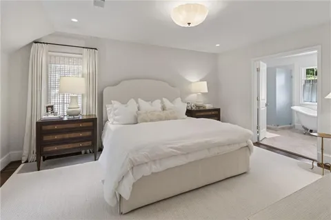 a large bed sitting in a bedroom and chair