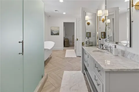 a large bathroom with a granite countertop sink a toilet a mirror and shower
