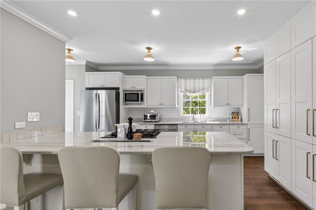 755 Greenview Avenue Northeast Atlanta, GA 30305 - Photo 7 of 28 a kitchen with stainless steel appliances a microwave a stove a sink dishwasher a refrigerator and white cabinets with wooden floor