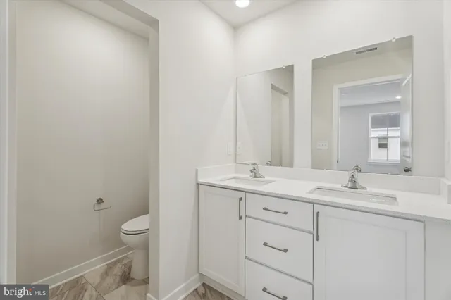 a bathroom with a toilet a sink and mirror