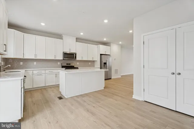 a kitchen with white cabinets and stainless steel appliances