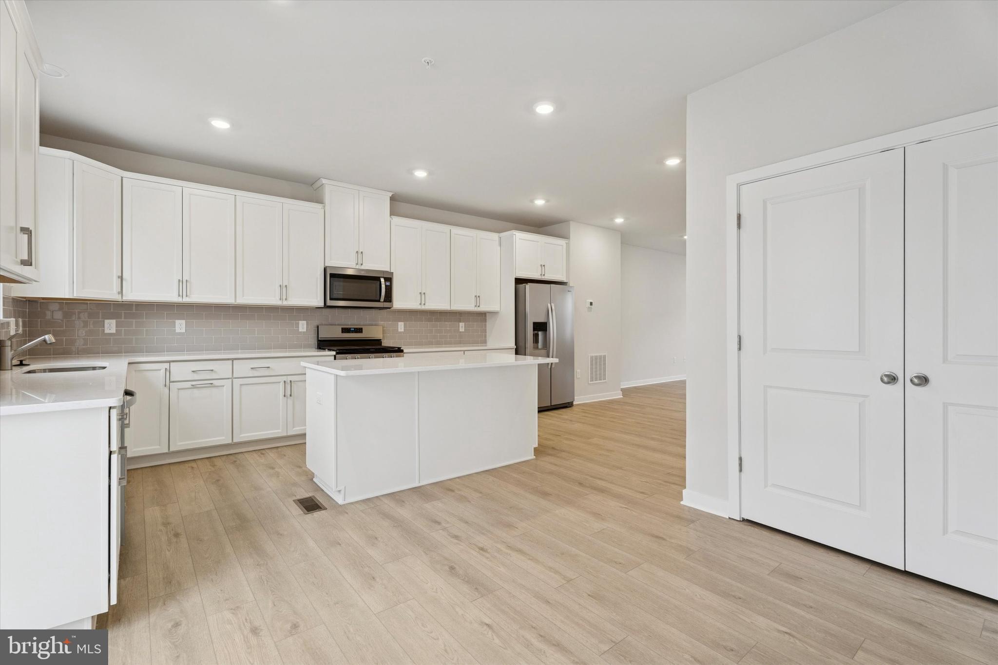 19 East Front Street Bridgeport, PA 19405 - Photo 7 of 25 a kitchen with white cabinets and stainless steel appliances