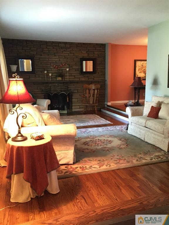 163 Normandy Road Colonia, NJ 07067 - Photo 2 of 14 a living room with furniture and a fireplace