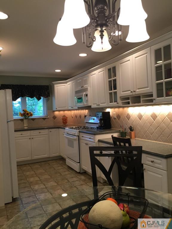 163 Normandy Road Colonia, NJ 07067 - Photo 4 of 14 a kitchen with stainless steel appliances granite countertop a sink and white cabinets