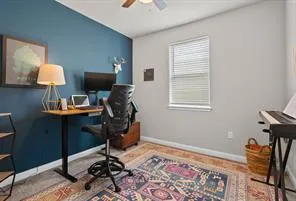 a view of a workspace with furniture and a window