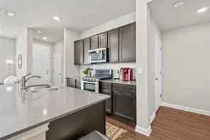 a kitchen with kitchen island granite countertop a sink cabinets and stainless steel appliances