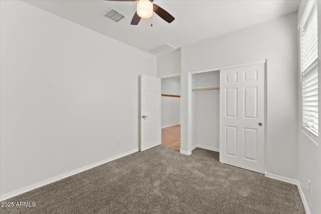 an empty room with a window and a fan