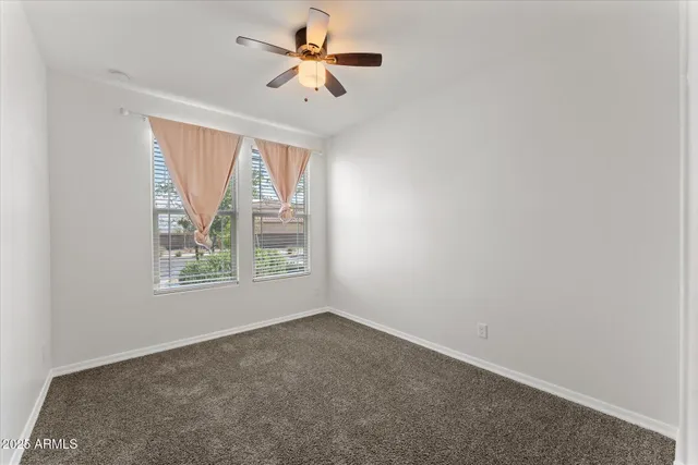 a bedroom with a large bed a chandelier and a window