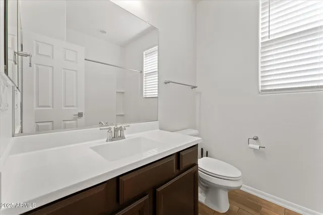 a bathroom with a granite countertop sink a toilet and a mirror