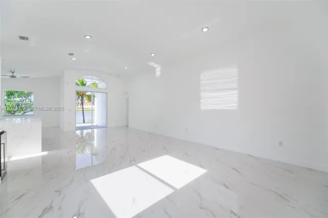 a view of a hallway with wooden floor windows and a living room