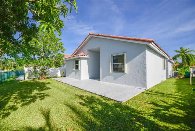 a front view of house with a garden