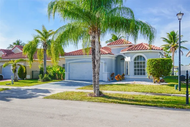 a row of palm trees sitting in front of a house