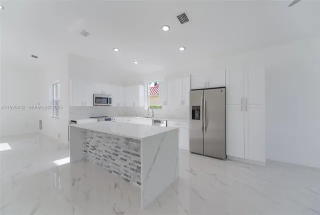 a view of kitchen with furniture and refrigerator