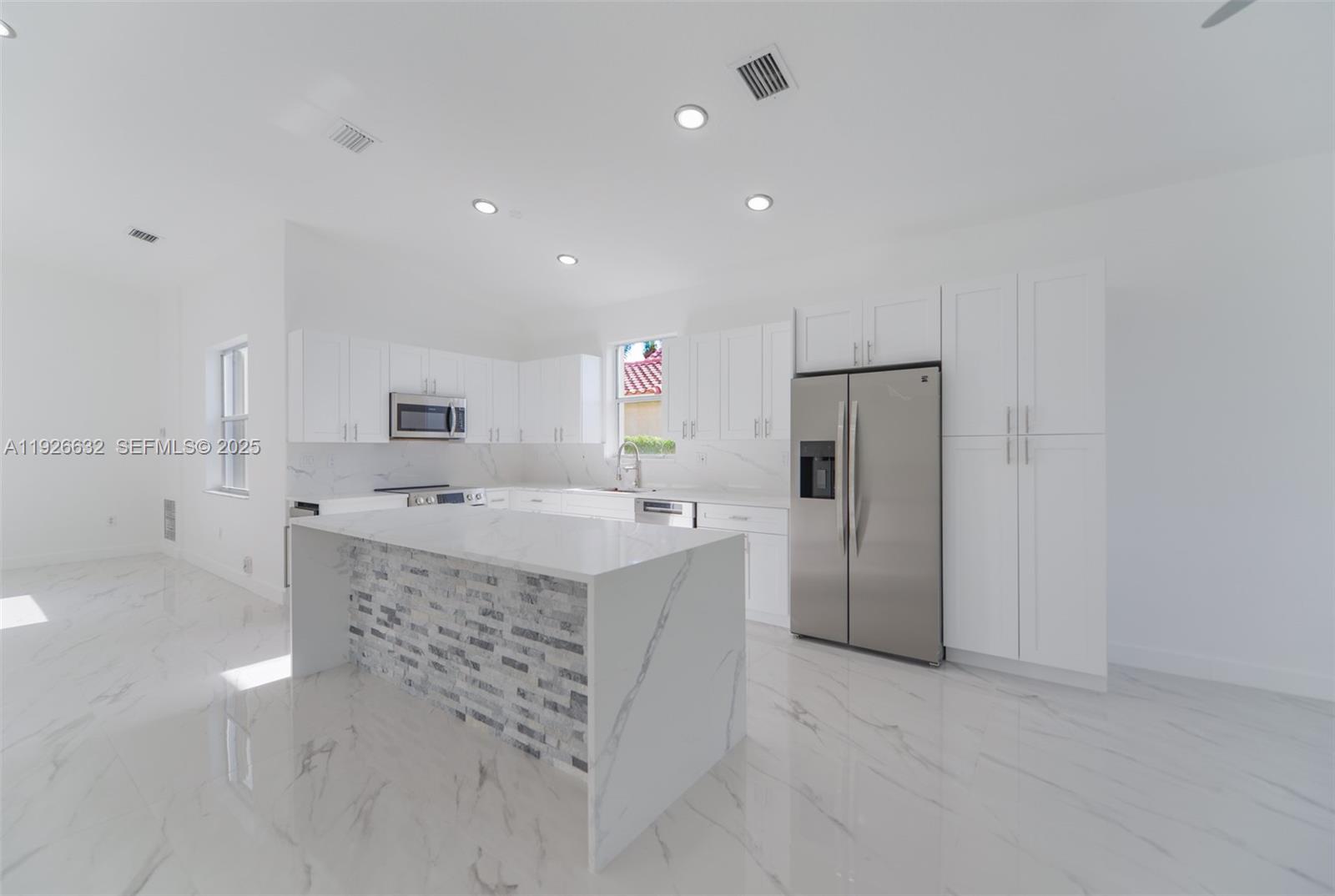 5290 Southwest 134th Avenue Miramar, FL 33027 - Photo 7 of 44 a kitchen with stainless steel appliances granite countertop a refrigerator and a sink