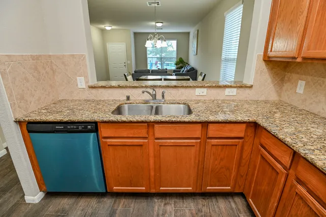 a kitchen with granite countertop wooden cabinets and a sink