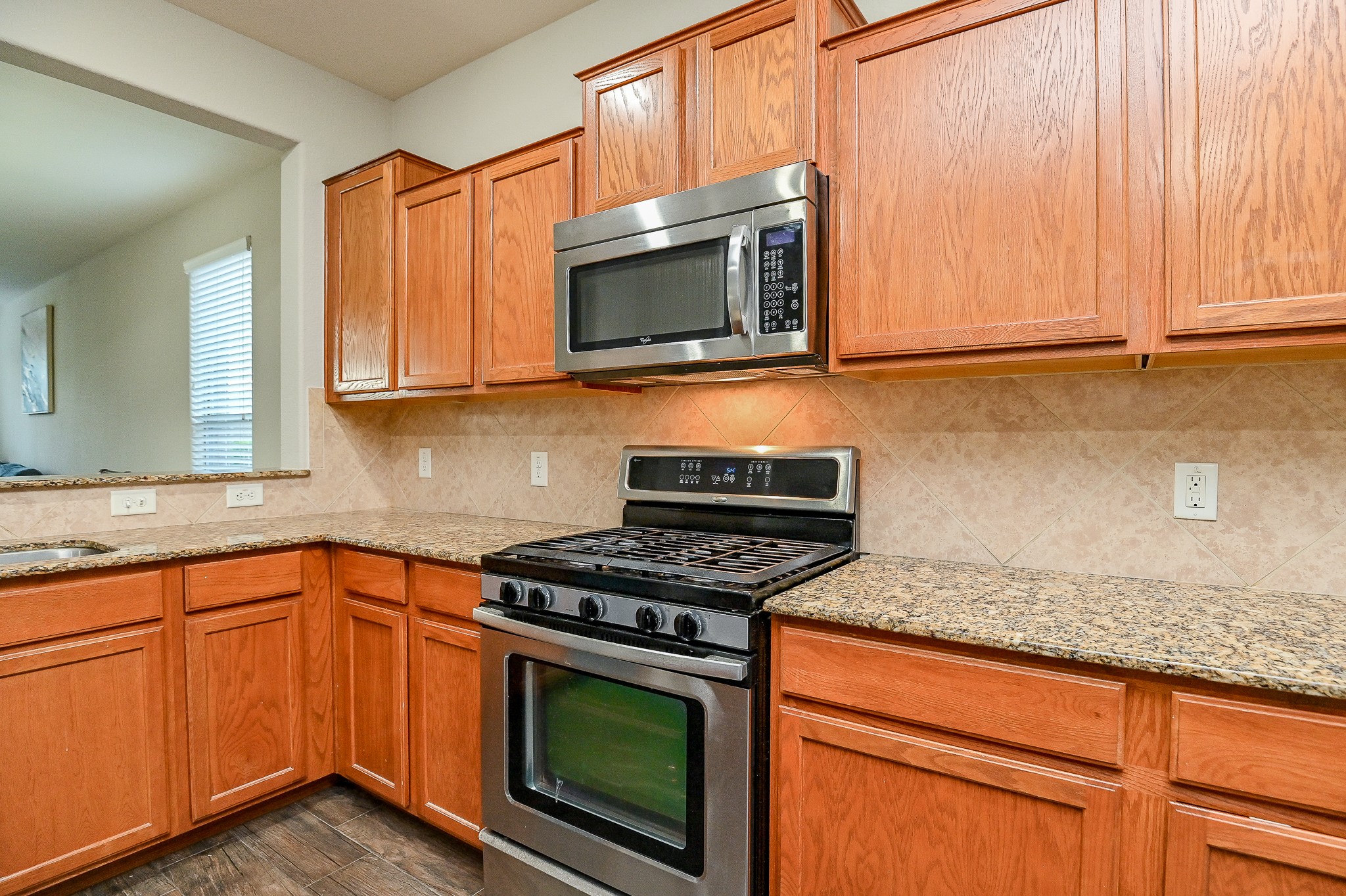 15406 Key Crest Lane Cypress, TX 77429 - Photo 20 of 47 a kitchen with granite countertop a stove top oven microwave and cabinets