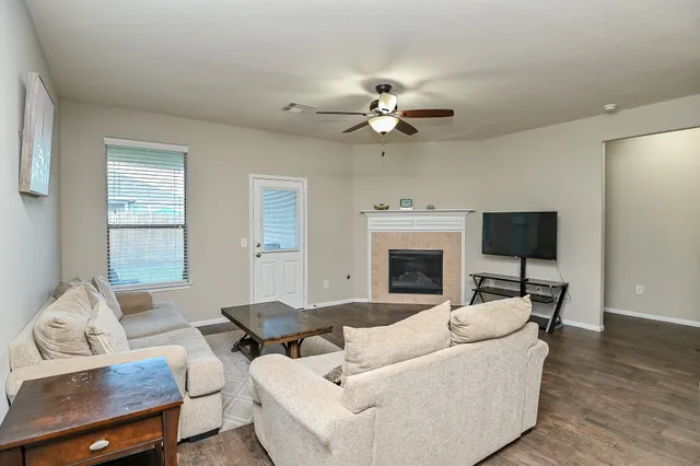 a living room with furniture a fireplace and a flat screen tv