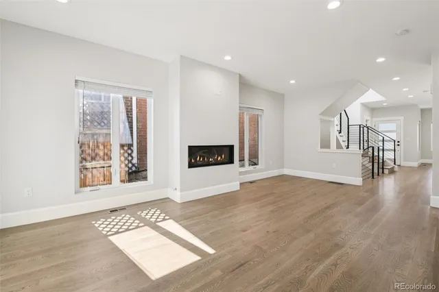 a view of an empty room with a window and fireplace
