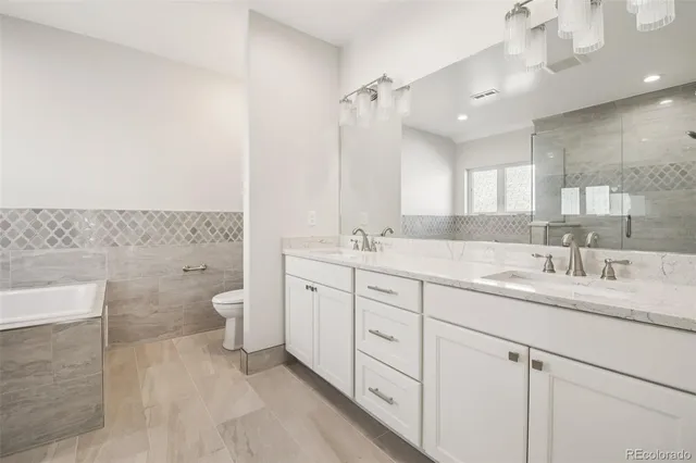 a bathroom with a granite countertop sink mirror and toilet