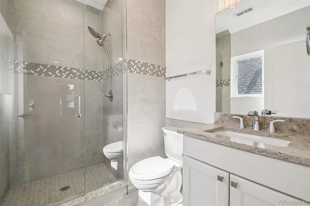 a bathroom with a granite countertop sink toilet and shower