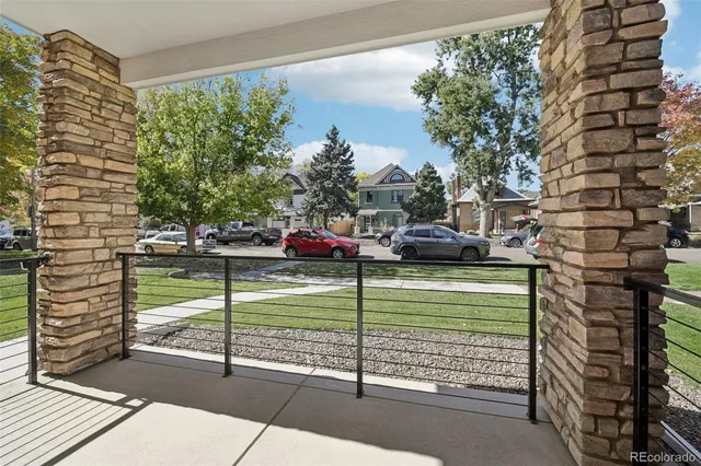 a view of a street with cars parked in front of a house