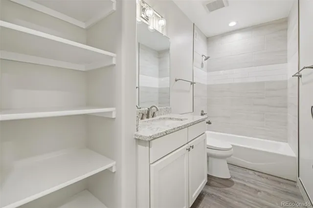 a bathroom with a granite countertop sink a toilet and bathtub