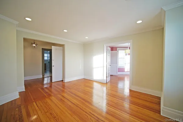 a view of an empty room with wooden floor and closet