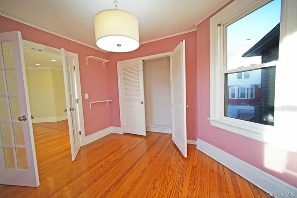 a view of a livingroom with wooden floor and a large window