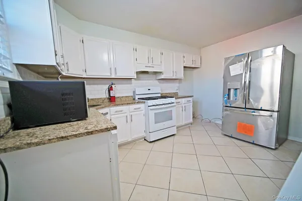 a kitchen with stainless steel appliances granite countertop a refrigerator sink and stove