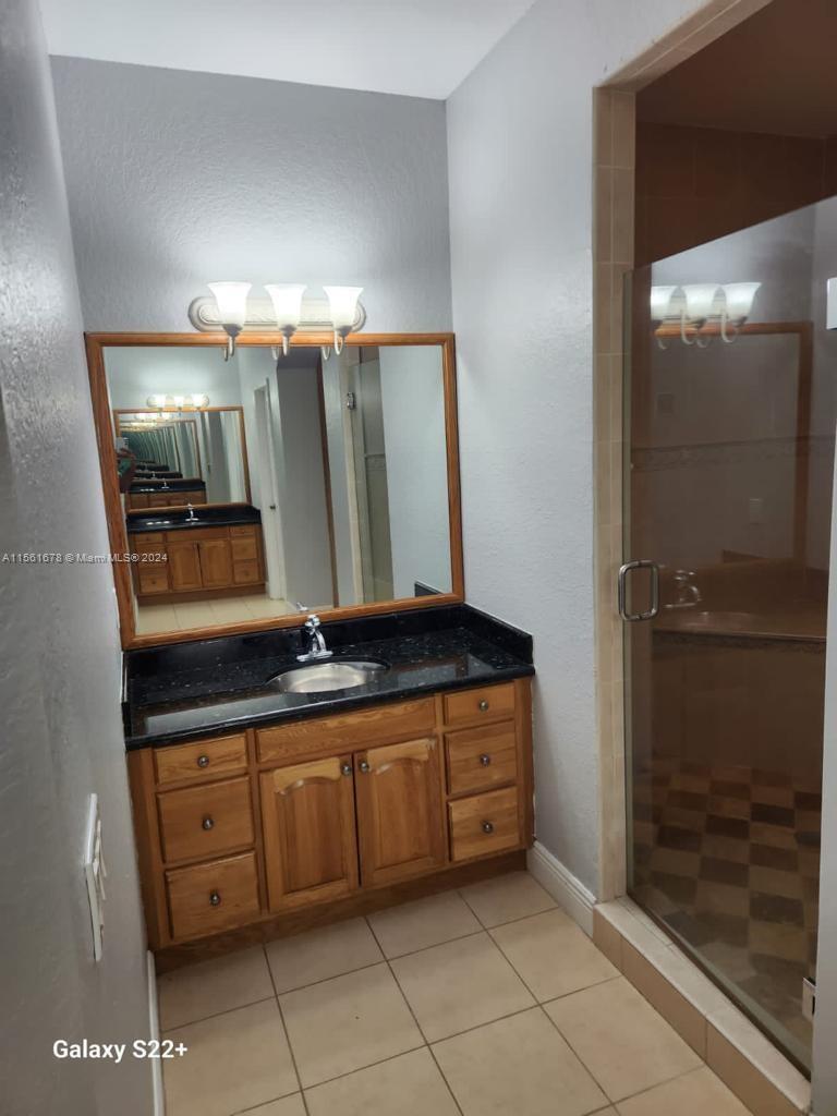 3187 Southwest 143rd Place Miami, FL 33175 - Photo 11 of 19 a bathroom with a sink a mirror and a shower