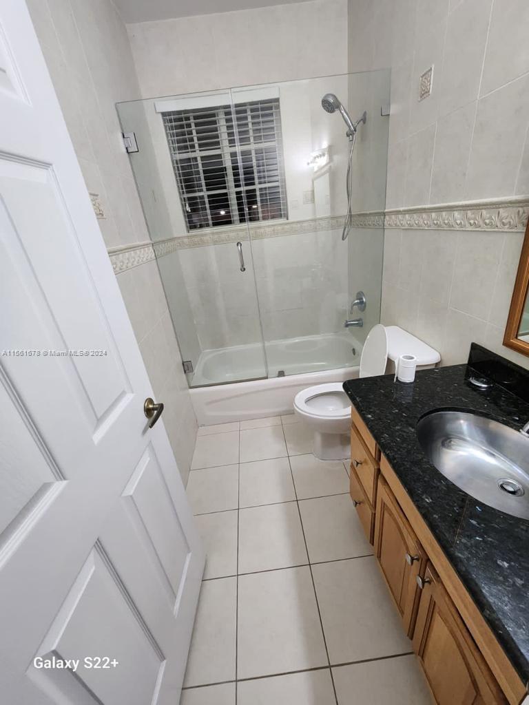 3187 Southwest 143rd Place Miami, FL 33175 - Photo 17 of 19 a bathroom with a granite countertop sink a toilet and a shower
