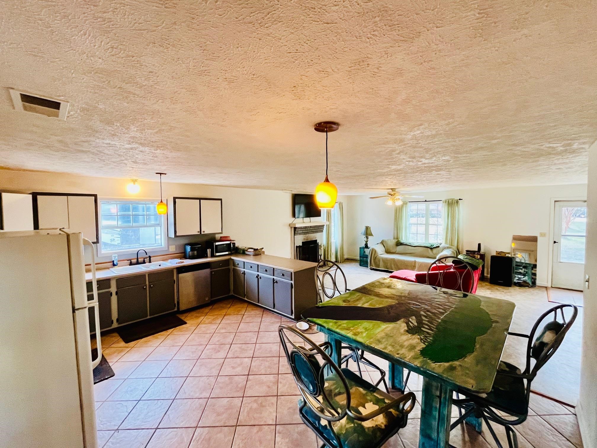 275 Fritton Spur Road Middleton, TN 38052 - Photo 31 of 31 Kitchen featuring stainless steel appliances, hanging light fixtures, open floor plan, a textured ceiling, and a fireplace