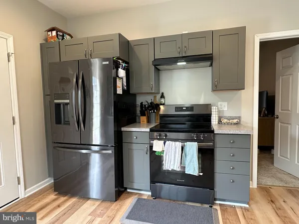 a kitchen with appliances a refrigerator and cabinets
