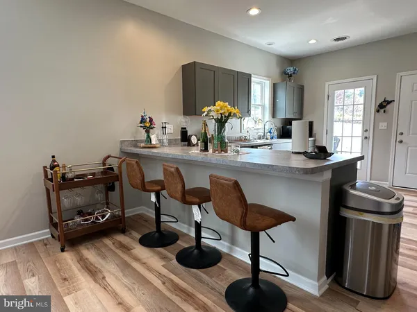 a kitchen with stainless steel appliances a dining table chairs and granite counter tops