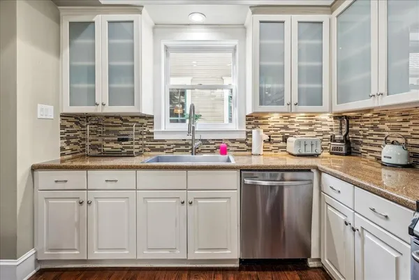 a kitchen with stainless steel appliances granite countertop a sink and a white cabinets