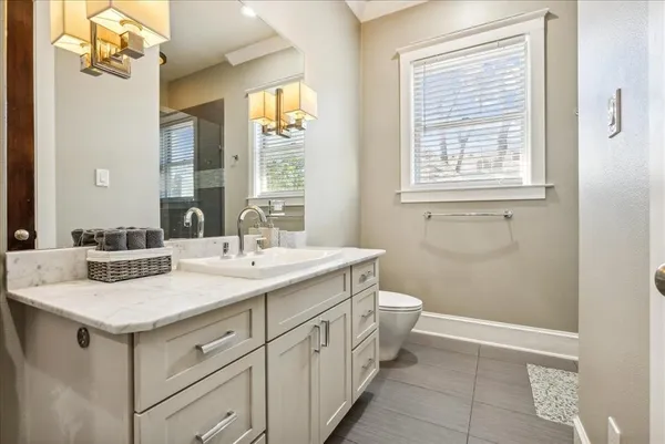 a bathroom with a sink a toilet and a mirror